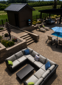 Luxury paver patio outdoor living space with seating wall, pool, and pergola in Denver